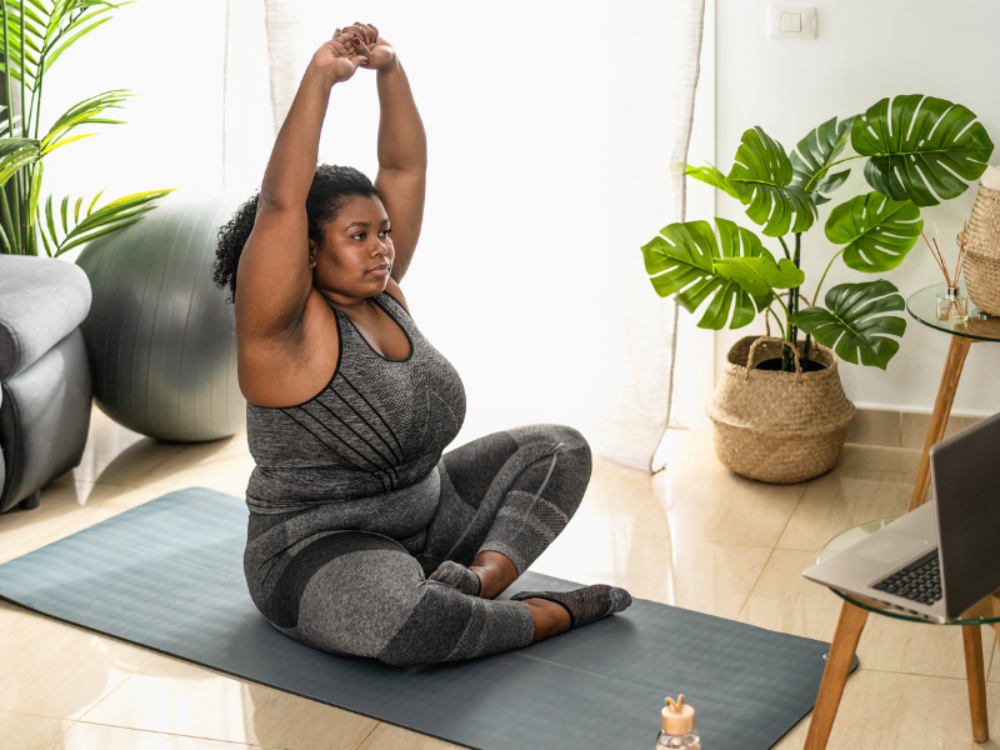 Woman exercising at home with laptop